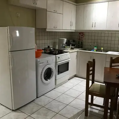 a kitchen with a refrigerator and a washing machine at Steps to Nea Chora beach Angela apt ,10min to town in Chania Town