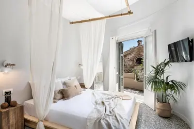 a white bedroom with a bed and a balcony at Artemide city places-Splantzia Square in Chania Town
