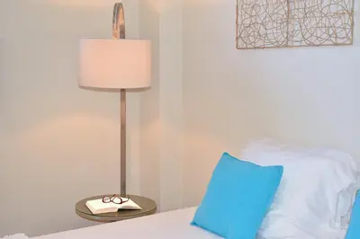a lamp sitting next to a bed with a blue pillow at Modi Home in Vrísai