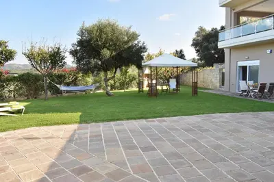 a patio with a hammock and a swing at Modi Home in Vrísai