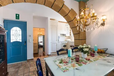 a kitchen and dining room with a blue door at Villa Ariadne in Stalos