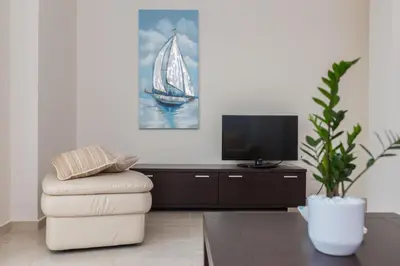 a living room with a chair and a tv at Geas House Thalassa in Kolymvari