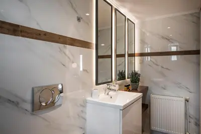 a white bathroom with a sink and a mirror at Sun Ray Luxury Apartments in Agia Marina Nea Kydonias