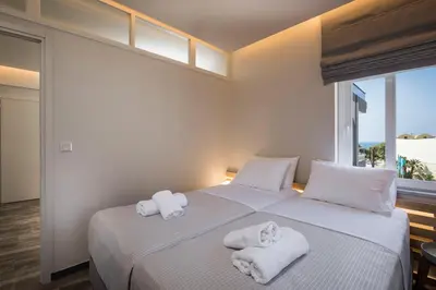 a bedroom with two beds with towels on them at Sun Ray Luxury Apartments in Agia Marina Nea Kydonias