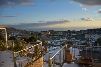 a balcony with a view of a city with snow at Madares Apartments Anopolis in Anopoli Sfakion
