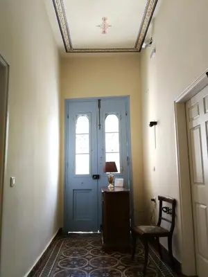 a hallway with a blue door and a chair and a table at Apollon Hotel in Chania Town