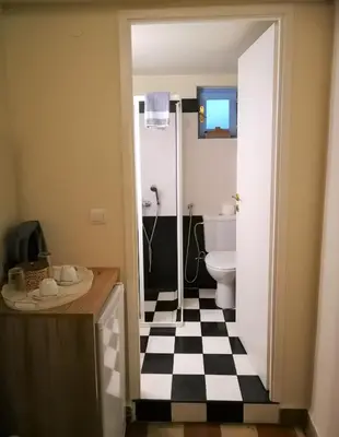 a bathroom with a black and white checkered floor at Apollon Hotel in Chania Town