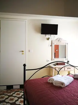 a bedroom with a bed with a red blanket and a mirror at Apollon Hotel in Chania Town