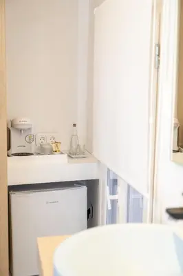 a white kitchen with a sink and a refrigerator at Nine in Chania Town