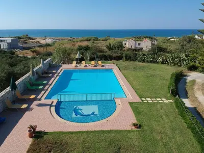 a swimming pool with the ocean in the background at Christiana Apartments in Gerani Chanion