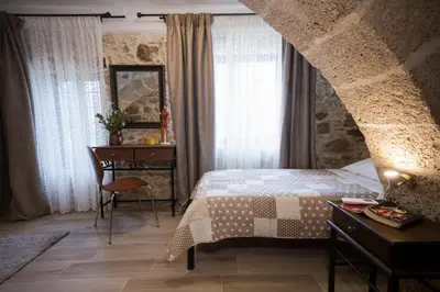 a bedroom with a bed and a table and a desk at Μylos in Kissamos