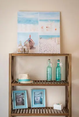 a wooden shelf with pictures and bottles on it at Villa Rebecca in Agia Marina Nea Kydonias