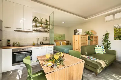 a kitchen and living room with a table and a couch at Olive Lemon Biophilic House & Lush Forest Garden in Vamos