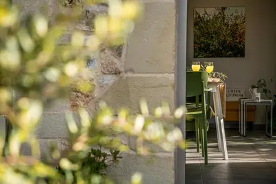 a dining room with a table with a green chair at Olive Lemon Biophilic House & Lush Forest Garden in Vamos