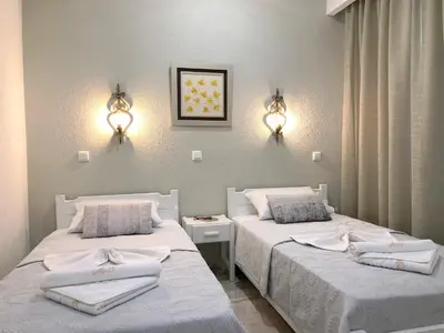 a bedroom with two beds with towels on them at Maria Suites in Plataniás