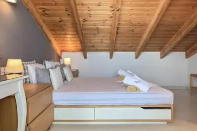 a bed in a room with a wooden ceiling at Alisahni Villa & Suite in Kato Daratso