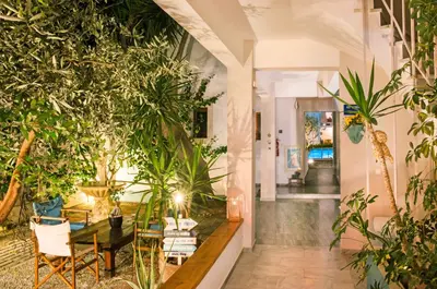 a hallway with plants and a table and chairs at Tree of Life Art Hotel in Agia Marina Nea Kydonias