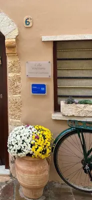 a bike parked in front of a building with flowers at Calle Veneziana in Chania Town