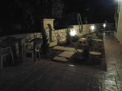 a garden at night with a chair and lights at father's house in kissamos in Korfalónas