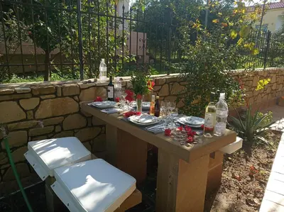 a table with food and drinks on it in a garden at father's house in kissamos in Korfalónas