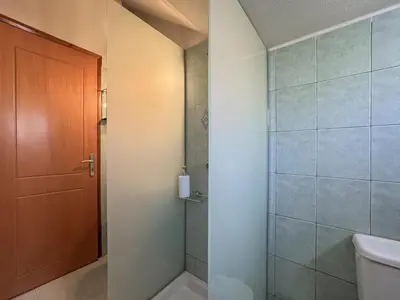 a bathroom with a shower and a toilet and a door at Alisahni Home 1 in Kato Daratso