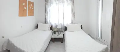 two twin beds in a room with a window at Eva's House in Kissamos
