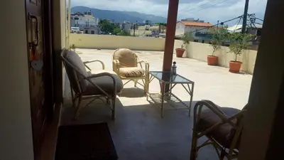 a patio with two chairs and a glass table at Penthouse in Chania Town