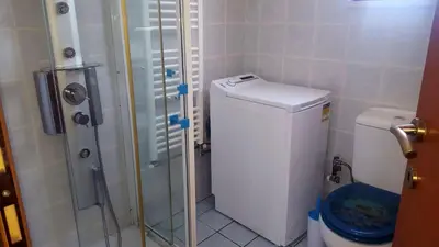 a small bathroom with a toilet and a shower at Penthouse in Chania Town