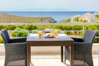 a table with a plate of food on a balcony at Luxury Villa Stella with private swimming pool in Tersanas