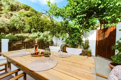 a wooden table with wine glasses and a bowl of fruit at Anna's Village House in Perivólia