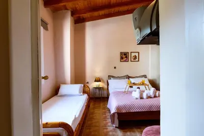a bedroom with two beds and a tv in it at Anna's Village House in Perivólia