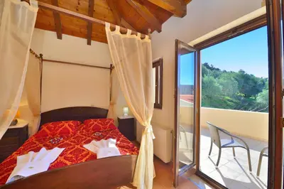 a bedroom with a bed and a large window at Maria Villas in Kissamos