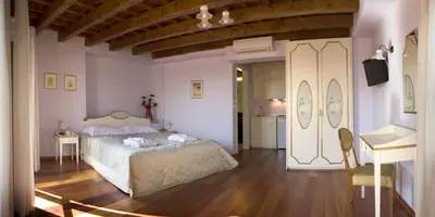 a bedroom with a bed and a table and a kitchen at Palazzo Duca in Chania Town