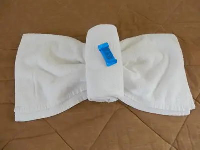 a white towel on the floor with a blue item on it at Babis Apartments in Plataniás