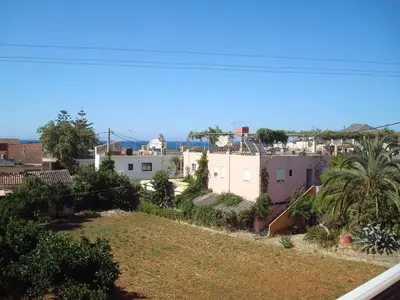 a view of a city with houses and palm trees at Babis Apartments in Plataniás