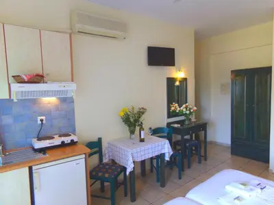 a kitchen with a table and chairs in a room at Katerina Seaside Studios in Plataniás