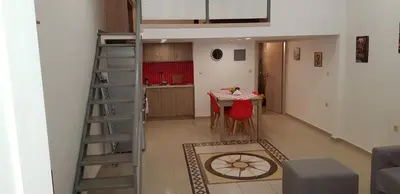 a room with a table and a kitchen with a ladder at Rodoula Luxury Αpartment 2 in Chania Town