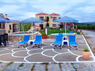 a patio with chairs and tables and umbrellas at Drapanias BeachFront Apartments - Marinakis in Kissamos