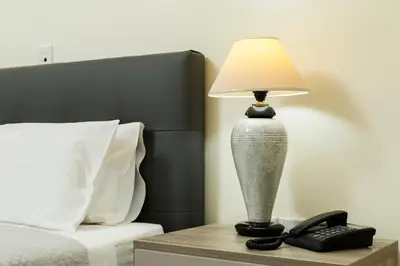 a lamp on a night stand next to a bed at Gramvoussa Bay in Kissamos