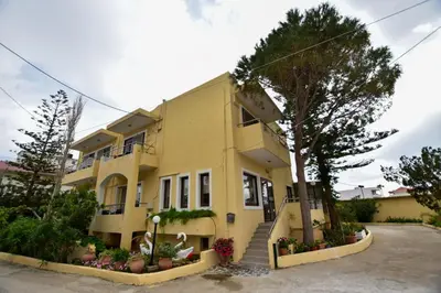 a yellow house with a tree in front of it at Hotel Aghas Paleochora in Palaiochóra