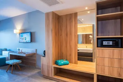 a room with a bathroom with a bed and a television at Solimar Aquamarine Resort in Gerani Chanion
