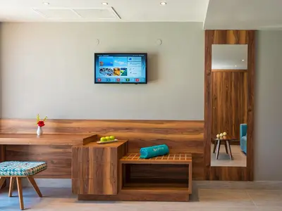 a living room with a tv on a wall at Solimar Aquamarine Resort in Gerani Chanion