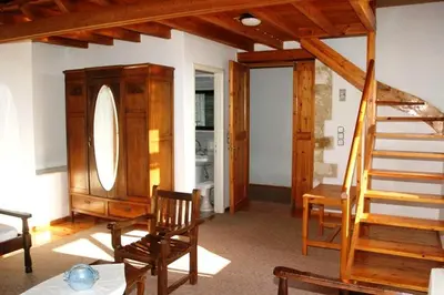 a living room with a staircase and a table and chairs at Oasis Guesthouse in Chania Town