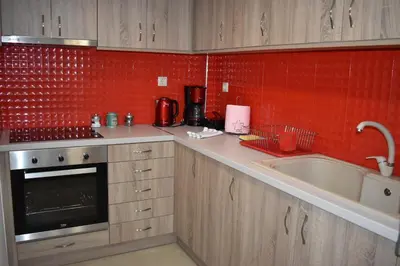 a kitchen with a sink and a red tile wall at Rodoula Luxury Αpartment 3 in Chania Town