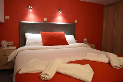a bedroom with a large bed with red walls at Rodoula Luxury Αpartment 4 in Chania Town