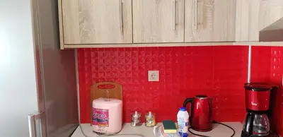 a kitchen counter with a sink and a red wall at Rodoula Luxury Αpartment 4 in Chania Town