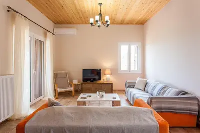 a living room with a couch and a tv at Villa Vendema in Arménoi