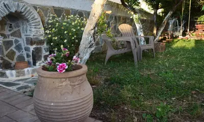 a large vase with flowers in it next to a chair at Central House with Quiet Garden in Kissamos