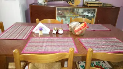 a wooden table with pink place mats on top of it at Sitzanaki Home in Chania Town