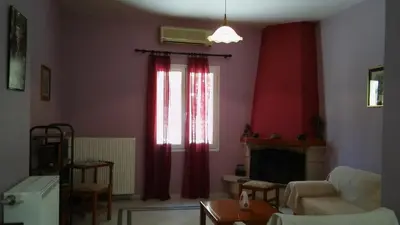 a living room with red curtains and a fireplace at Sitzanaki Home in Chania Town